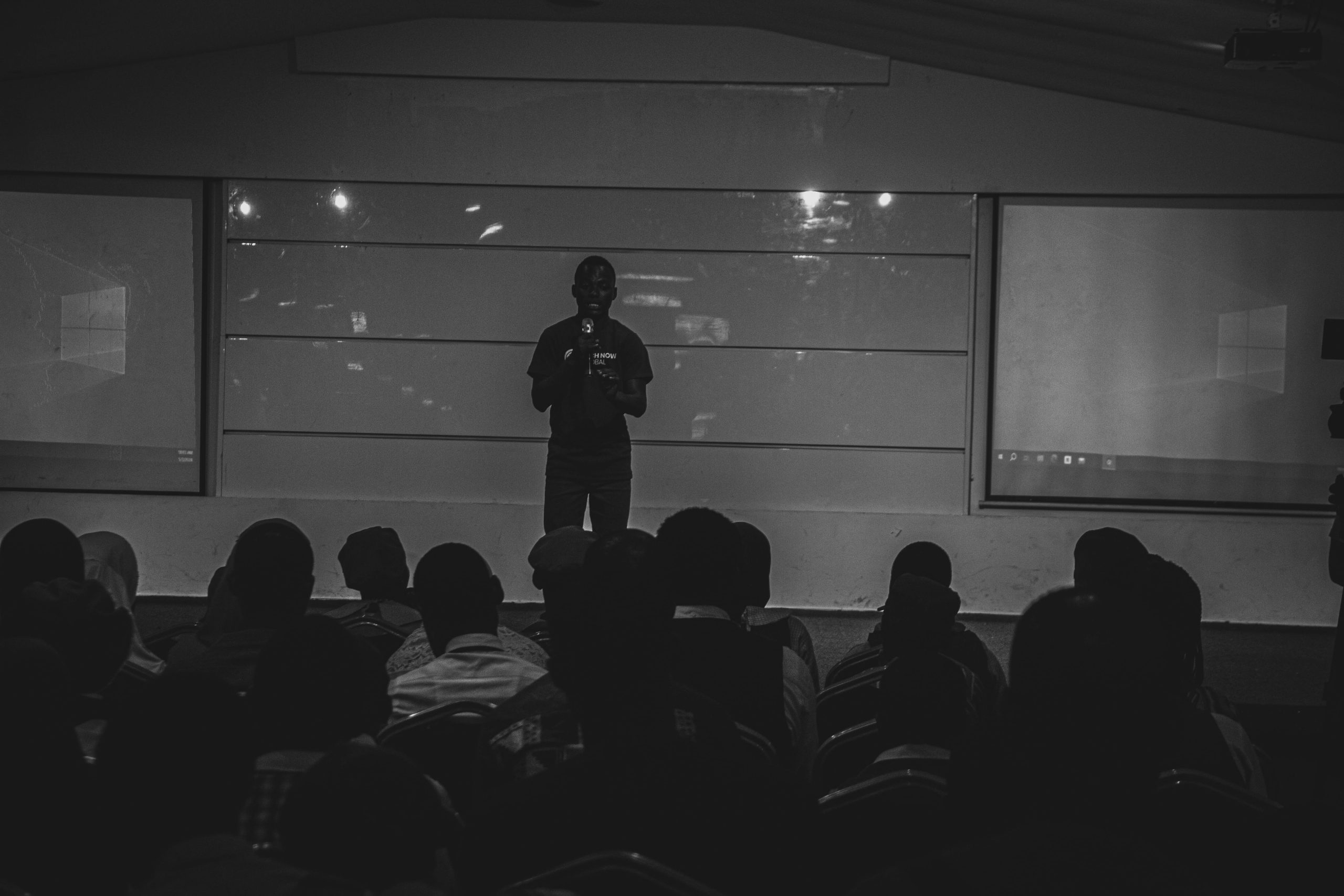 A speaker addressing a full room at a Tech Now Global event